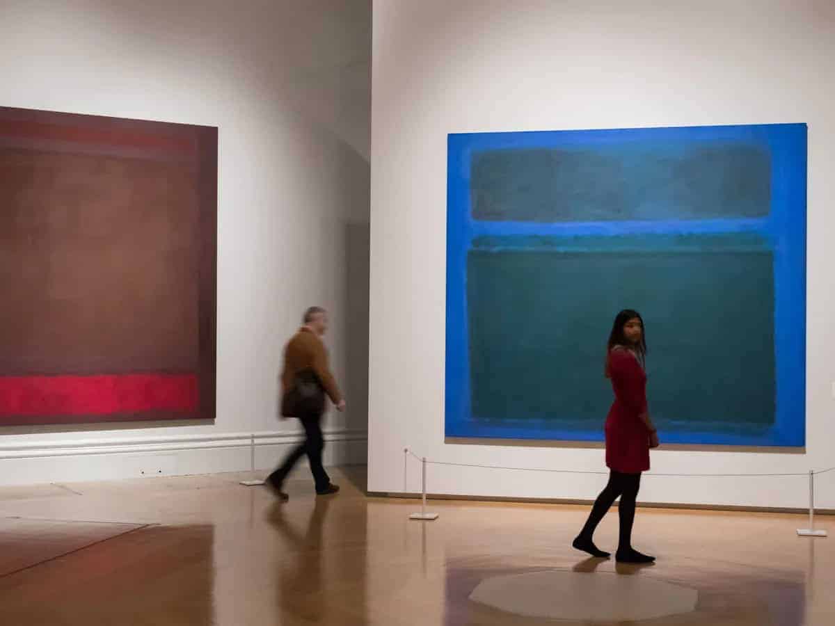 Viewer examining matte Rothko painting in gallery without glare