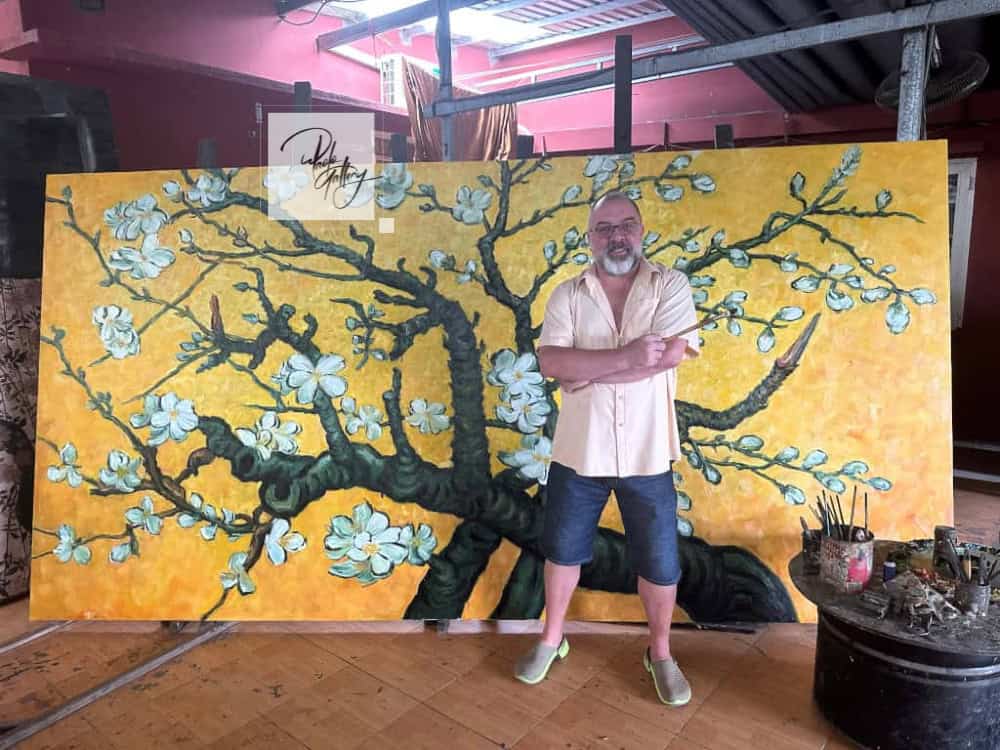 Artist hand-painting a large wall canvas painting in Paolo Gallery studio
